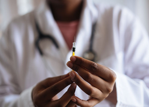 [Image of a doctor with an injection, Credit to Pexels]