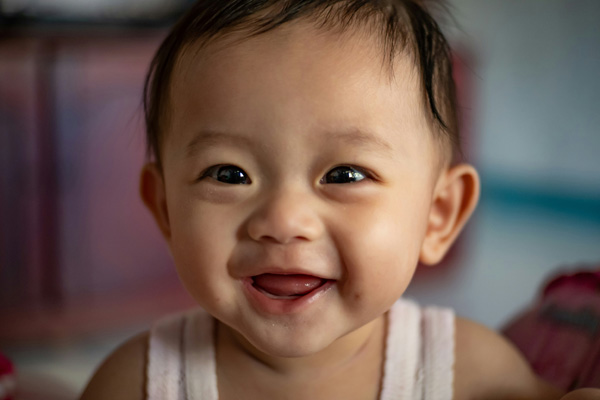 [A Baby Smiling. Photo Credit to Unsplash]