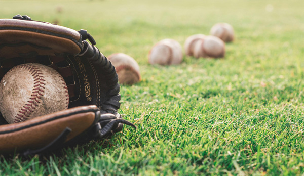 [White baseball ball on brown leather baseball mitt. Photo Credit to Pixabay]